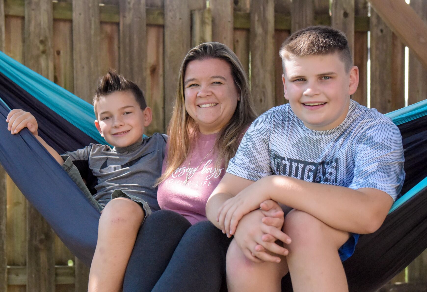Staci Ortbal, center, and her sons Joshua, 8, left, and Caleb, 11, right, sit in a hammock